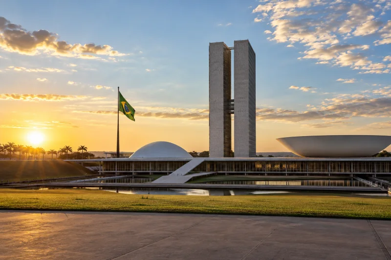 El edificio del Congreso Nacional de Brasilia y la bandera brasileña al amanecer.